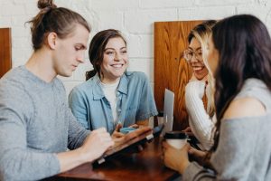 Group of students, studying, over coffee with technology