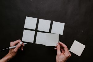 Person holding white post-it notes and organizing