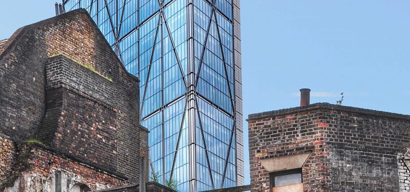 View of London with  old, derelict buildings in foreground and tall, modern, shiny skyscraper behind.